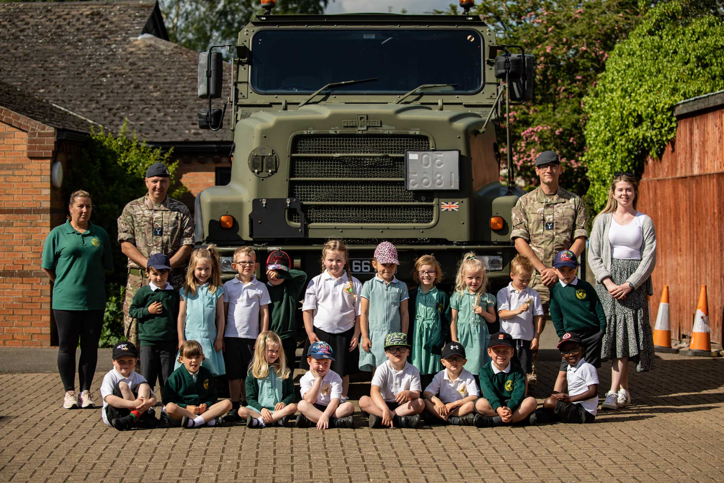 Reception year pupils with a 2MT Squadron Oshkosh truck and SAC Oliver Murden (left) and SAC James Shute (right)